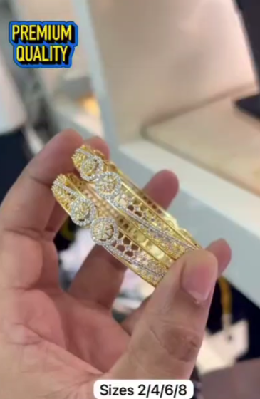 Gold-plated bangles feature intricate, machine-cut CNC designs