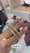 Pair of gold-plated bangles studded with white American diamonds and red square stones